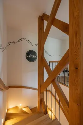 a staircase in a house with wooden beams at House Natura Savica in Bohinj