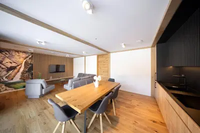 a dining room with a wooden table and chairs at House Natura Savica in Bohinj
