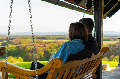 a man and a woman sitting on a swing at WeinSpitz - Wellness House in Miklavž pri Ormožu