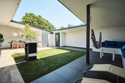 an open living room with a patio with an american flag at Matic Murgle Atrium Apartment in Ljubljana
