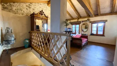 a living room with a staircase in a house at Krasna Hiška - Authentic Heritage Home in Sežana