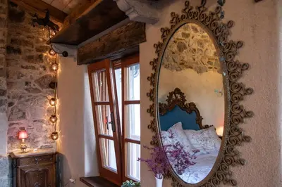 a large mirror on the wall of a bedroom at Krasna Hiška - Authentic Heritage Home in Sežana