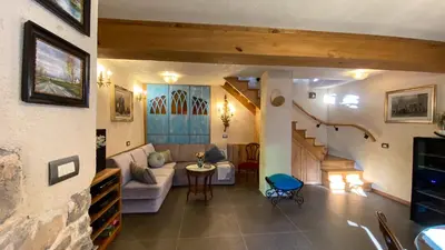 a living room with a couch and a staircase at Krasna Hiška - Authentic Heritage Home in Sežana