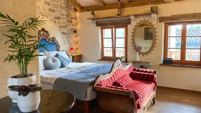 a bedroom with a king sized bed and a couch at Krasna Hiška - Authentic Heritage Home in Sežana