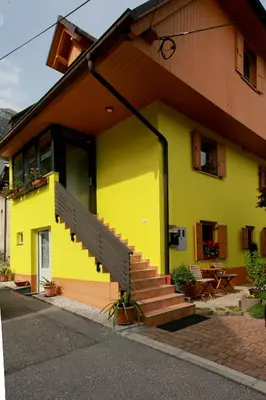 a yellow building with a staircase on the side of it at Apartma Dvor Milena in Bovec
