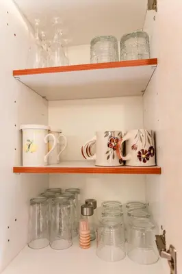a kitchen pantry with jars and dishes on shelves at Apartma Dvor Milena in Bovec