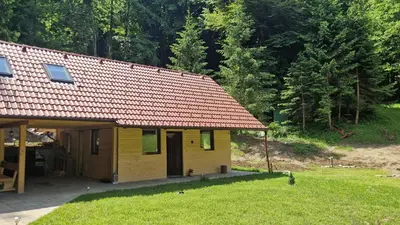 a small yellow house with a red roof at Zeleni raj Green Paradise House in Žužemberk