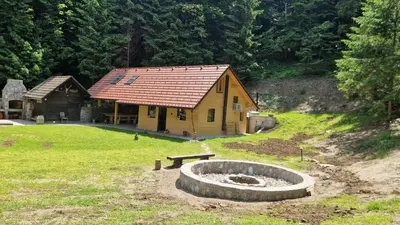 a log cabin with a fire pit in front of it at Zeleni raj Green Paradise House in Žužemberk