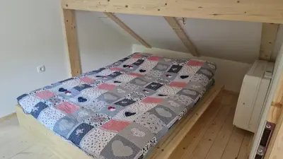 a bed in a room with a quilt on it at Zeleni raj Green Paradise House in Žužemberk