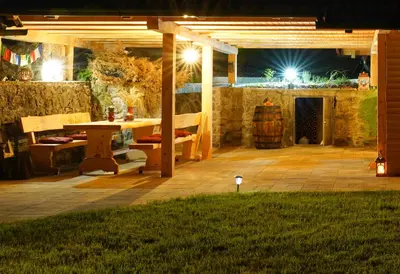 a patio at night with a table and chairs at Zeleni raj Green Paradise House in Žužemberk