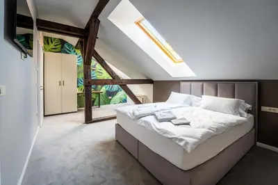 a bedroom with a bed and a large window at GRAND CENTRAL LJUTOMER in Ljutomer