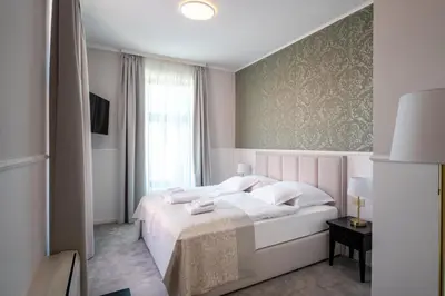 a bedroom with a white bed and a window at GRAND CENTRAL LJUTOMER in Ljutomer