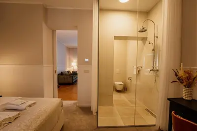 a bathroom with a shower and a bed in a room at GRAND CENTRAL LJUTOMER in Ljutomer