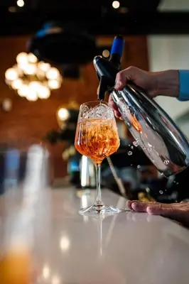a person is pouring wine into a wine glass at GRAND CENTRAL LJUTOMER in Ljutomer