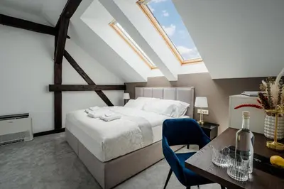 a bedroom with a bed and a desk and a table at GRAND CENTRAL LJUTOMER in Ljutomer