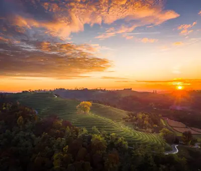 a sunset over a field with the sun setting in the background at GRAND CENTRAL LJUTOMER in Ljutomer