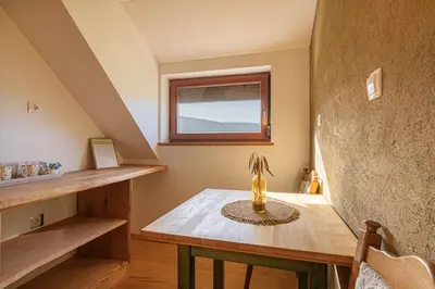 a room with a wooden table and a window at Organic Homestead Mikl in Slovenj Gradec