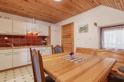 a kitchen with a wooden table and a wooden ceiling at Organic Homestead Mikl in Slovenj Gradec