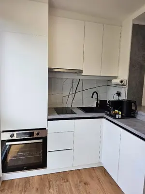 a white kitchen with white cabinets and a sink at TOP - Ljubljana's Central Gem - free public parking in Ljubljana