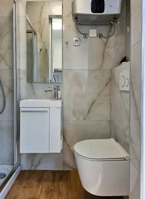 a bathroom with a toilet and a sink and a mirror at TOP - Ljubljana's Central Gem - free public parking in Ljubljana