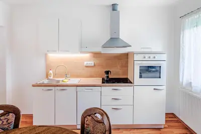 a kitchen with white cabinets and a sink at Apartment Pr' Štajercu with Free Onsite Parking in Bovec