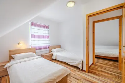 a bedroom with two beds and a mirror at Apartment Pr' Štajercu with Free Onsite Parking in Bovec