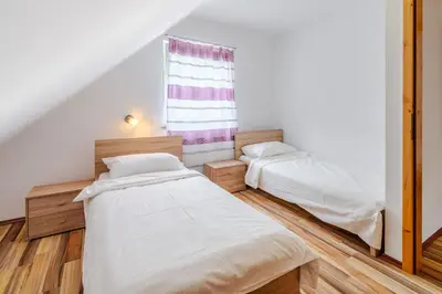 two beds in a room with a window at Apartment Pr' Štajercu with Free Onsite Parking in Bovec