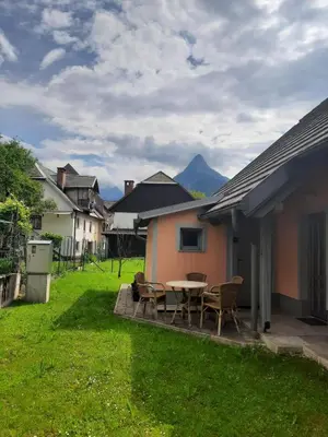 a patio with a table and chairs in a yard at Apartment Pr' Štajercu with Free Onsite Parking in Bovec