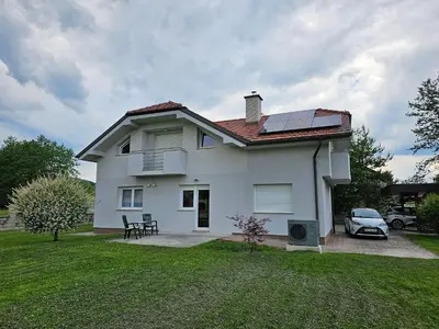 a white house with solar panels on the roof at Hišica ob Potoku in Podčetrtek