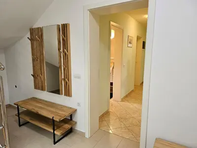 a hallway with a wooden bench and a mirror at Hišica ob Potoku in Podčetrtek