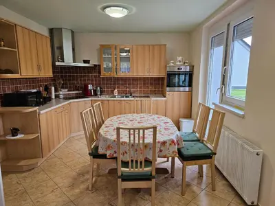 a kitchen with a table and chairs and a table and a kitchen at Hišica ob Potoku in Podčetrtek