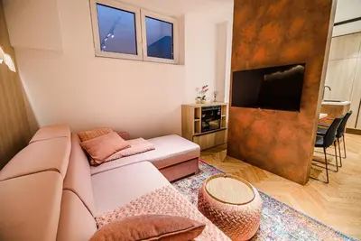 a living room with a couch and a flat screen tv at Apartments Slavec with Free Onsite Parking in Kranjska Gora