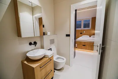 a bathroom with a sink and a toilet and a bed at Apartments Slavec with Free Onsite Parking in Kranjska Gora