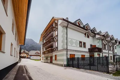 a white building with a fence on a street at Apartments Slavec with Free Onsite Parking in Kranjska Gora