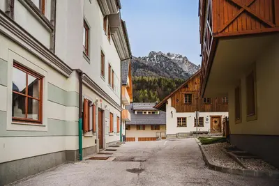 an alley between two buildings with mountains in the background at Apartments Slavec with Free Onsite Parking in Kranjska Gora