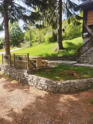 a wooden bench sitting on a stone wall at Počitniška hiša Lokve in Trnovo