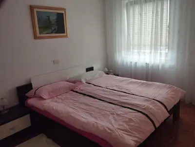 a bedroom with a bed with pink sheets and a window at Zala Apartment in Zgornje Škofije
