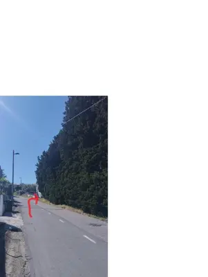 a person is flying a kite on a road at Zala Apartment in Zgornje Škofije
