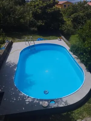 a large blue swimming pool on a patio at Zala Apartment in Zgornje Škofije