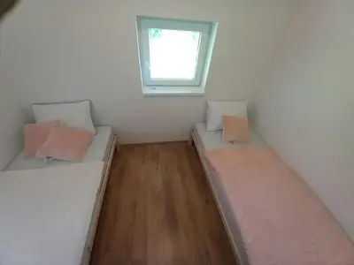 two beds in a small room with a window at Vineyard cottage foggy sea in Semič