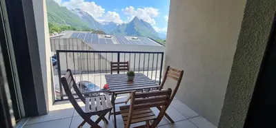 a table and chairs on a balcony with a view at Charming Bovec Apartment in Bovec