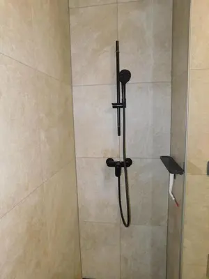 a shower with a black shower head in a bathroom at Charming Bovec Apartment in Bovec