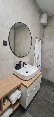 a bathroom with a white sink and a mirror at Charming Bovec Apartment in Bovec