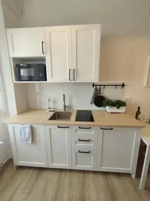 a kitchen with white cabinets and a sink at One-bedroom city apartment in Ljubljana