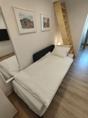 a small bed in a small room with stairs at One-bedroom city apartment in Ljubljana