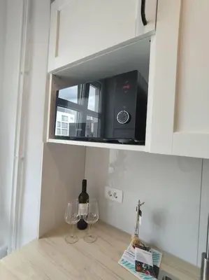 a kitchen with two wine glasses and a microwave at One-bedroom city apartment in Ljubljana
