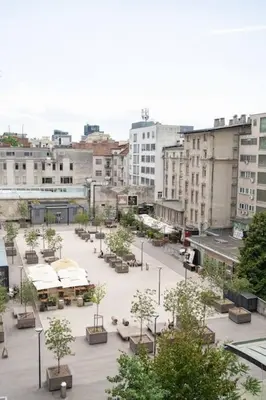 a city with a courtyard with trees and buildings at One-bedroom city apartment in Ljubljana