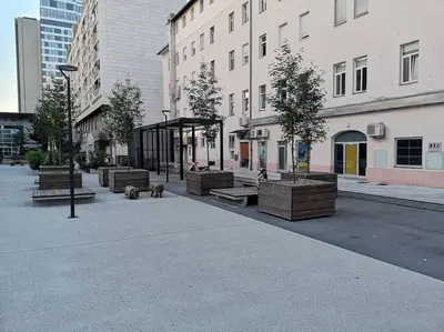 a group of benches on a city street with buildings at One-bedroom city apartment in Ljubljana