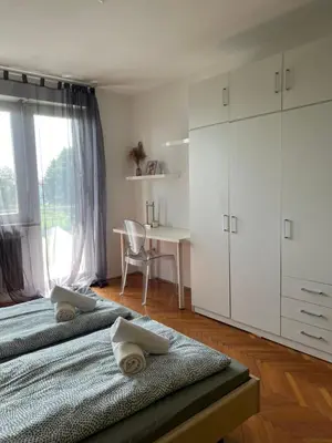a bedroom with two beds and a desk and a window at Apartment Ljubljana - Free parking in Ljubljana