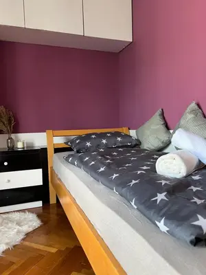 a bed in a bedroom with a purple wall at Apartment Ljubljana - Free parking in Ljubljana